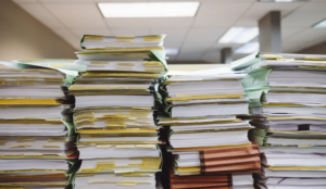 Stacks of documents demonstrating the need for board pack software